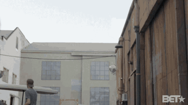 a man standing in front of a building with the beta logo on the bottom