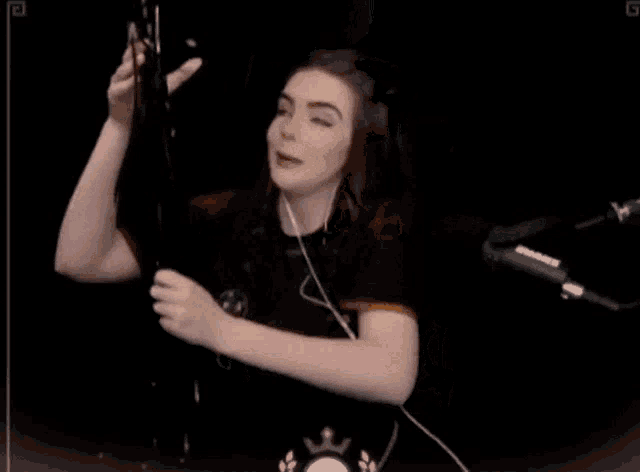a woman is holding a bunch of balloons in front of a microphone