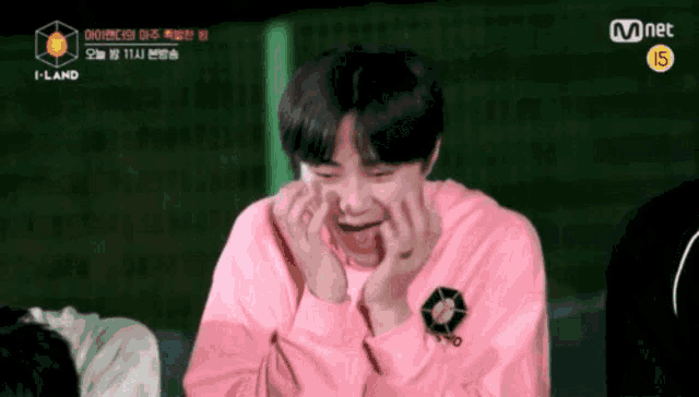 a boy in a pink sweater is making a funny face .