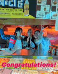 a group of people standing in front of a counter with the words congratulations written on it