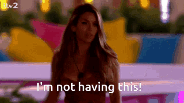 a woman says " i 'm not having this " while standing in front of a colorful background