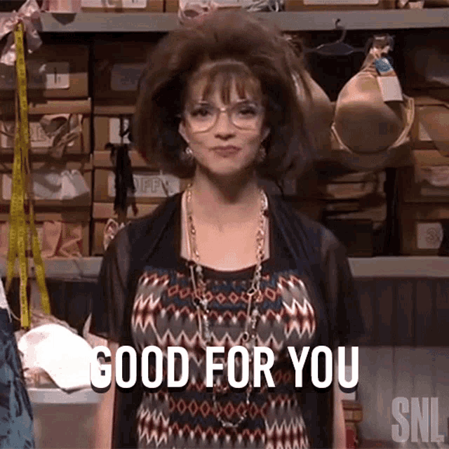 a woman says good for you in front of a shelf full of bras