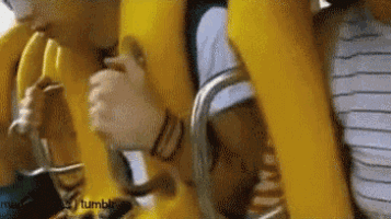 a person is eating a banana on a roller coaster ride .