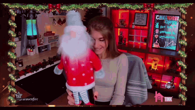 a woman is holding a stuffed santa claus in front of a sign that says challenger