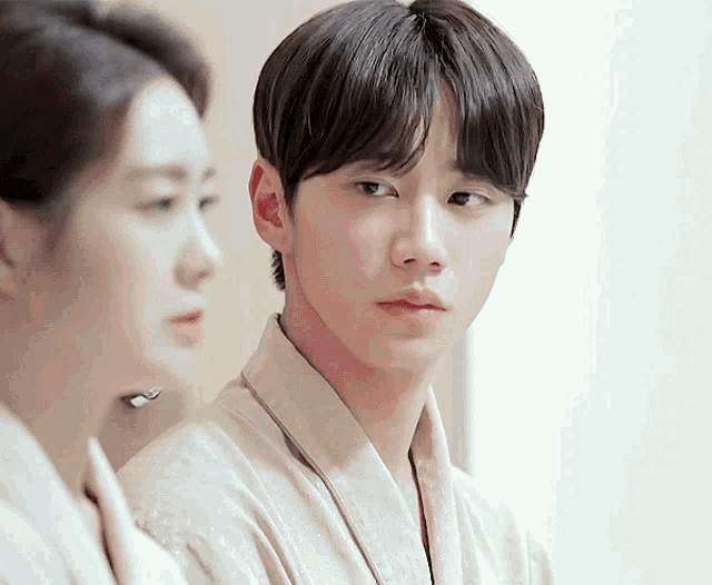 a man in a robe is looking at a woman