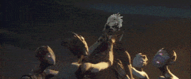 a group of aliens are standing around a statue of a person