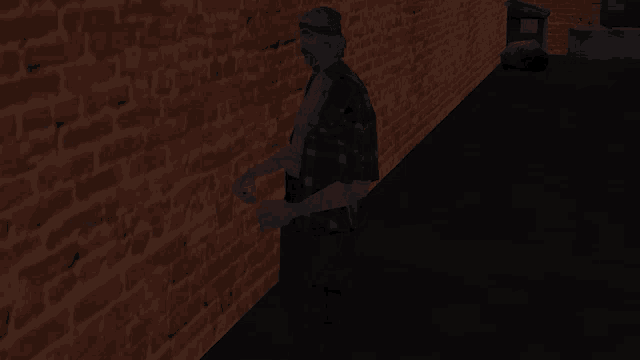 a man in a plaid shirt is standing next to a brick wall at night