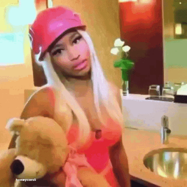 a woman in a red hat is holding a teddy bear .
