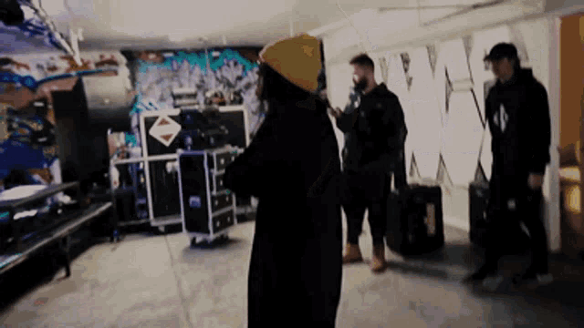 a group of people are standing in a room with graffiti on the wall and the word wmx