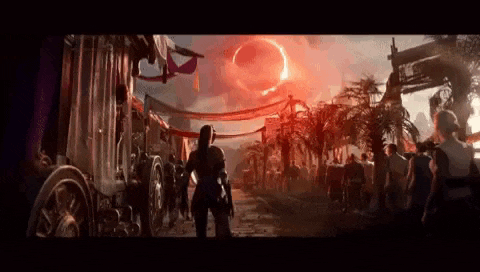 a group of people are walking down a street in front of a large red circle in the sky .