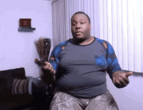 a man is sitting on a couch in a living room holding a bottle of beer .