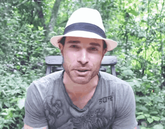 a man wearing a hat and a shirt that says ' serene ' on it