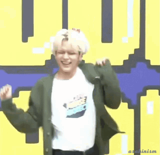 a man wearing a t-shirt that says peace project is dancing in front of a pixelated background