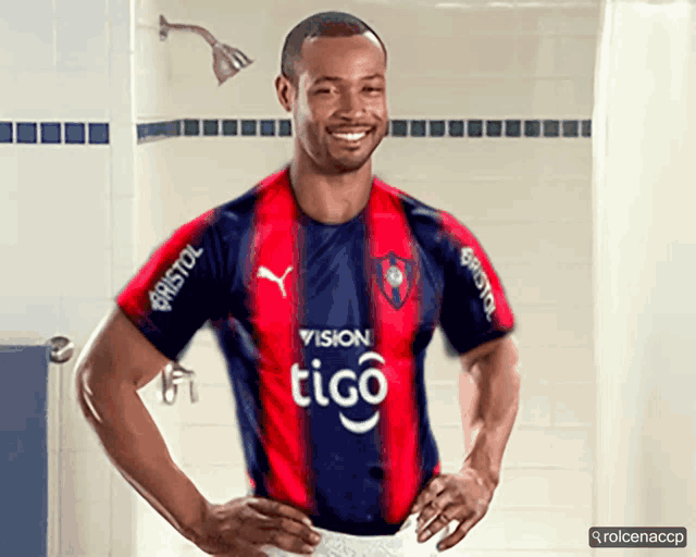 a man wearing a red and blue striped shirt that says tigo on it