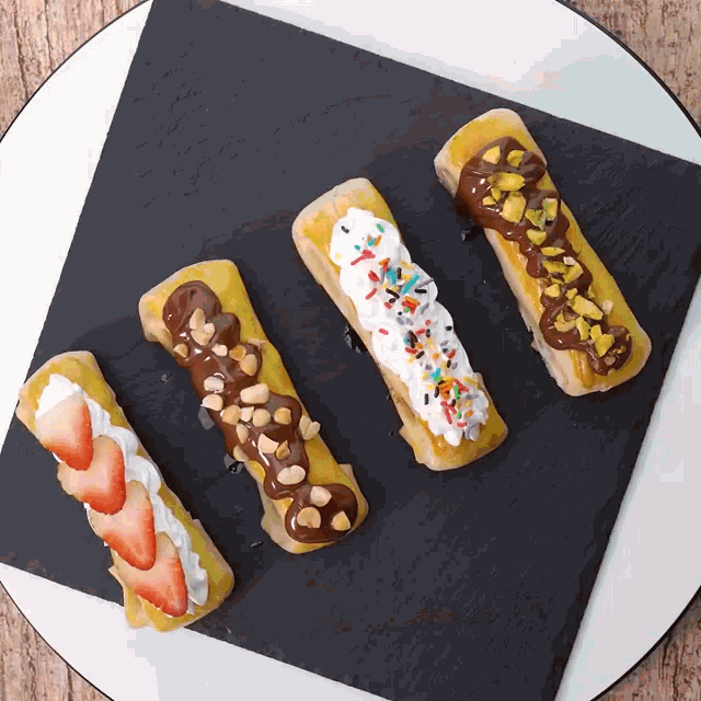 a white plate topped with four desserts with different toppings