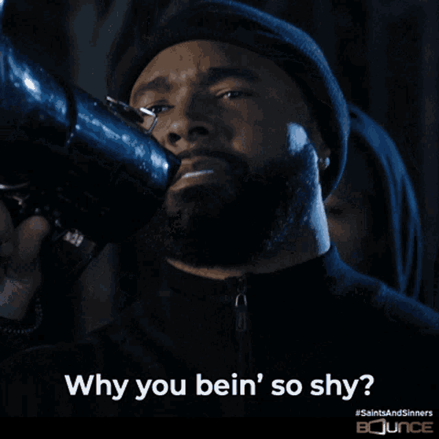 a man holding a camera with the words " why you bein ' so shy " on the bottom