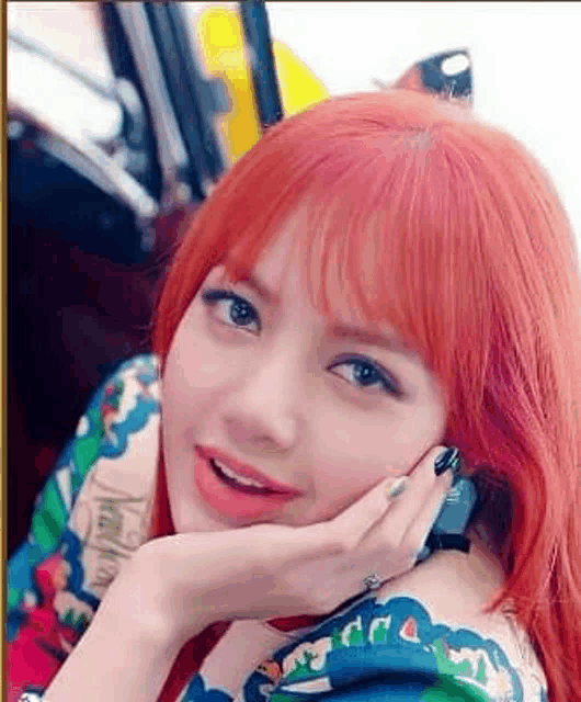 a close up of a woman with red hair and black nails .