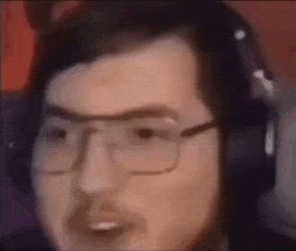 a man with glasses and headphones is making a funny face .