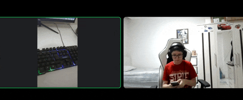 a boy wearing a red shirt that says ' strike ' on it sits in front of a keyboard