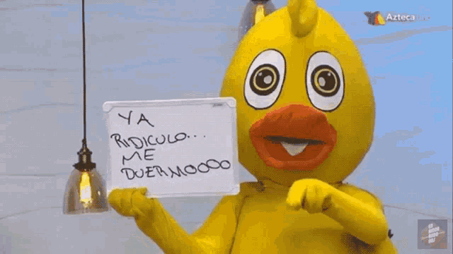 a yellow duck is holding a sign that says ya ridiculo me duermo00