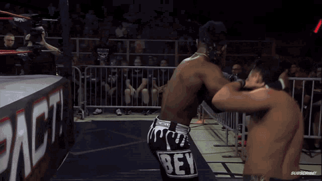 two wrestlers are fighting in a ring with a sign that says impact on it