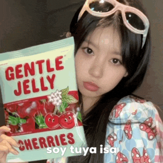 a girl wearing sunglasses is holding a bag of gentle jelly cherries .