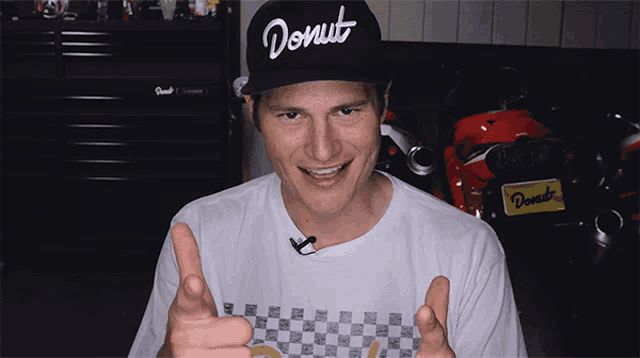 a man wearing a donut hat giving a thumbs up sign