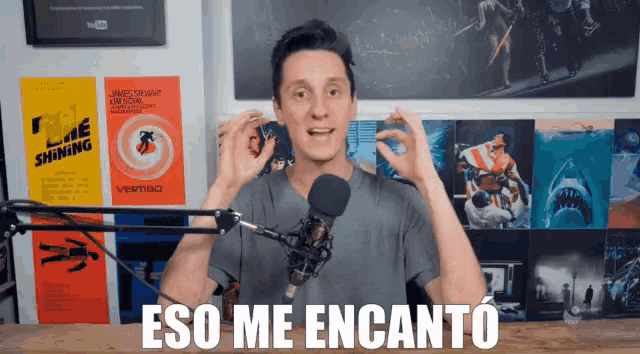 a man standing in front of a microphone with the words eso me encanto written below him