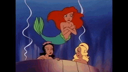 a group of mermaids are swimming in the ocean and ariel is standing next to them .