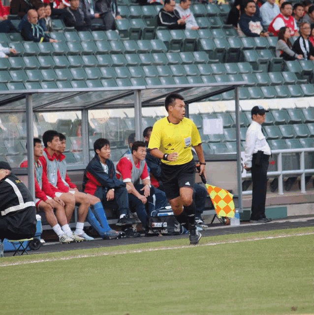 a soccer referee wearing a yellow shirt with the number 10 on it