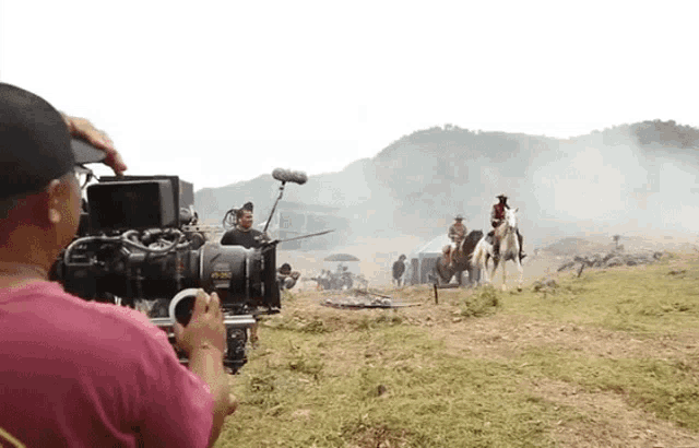 a cameraman is taking a picture of a man on a horse