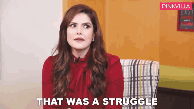 a woman in a red shirt is sitting in a chair and saying that was a struggle