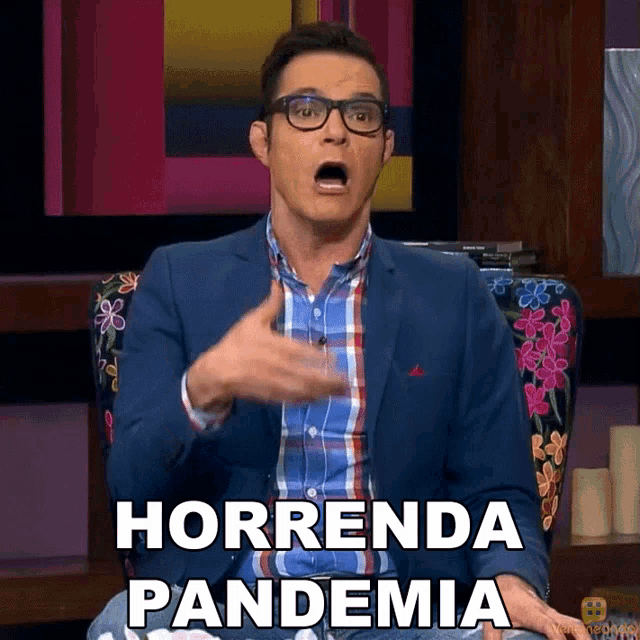 a man in a suit and plaid shirt is sitting in a chair and says horrrenda pandemia