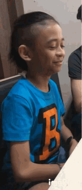 a young boy wearing a blue shirt with the number 8 on it