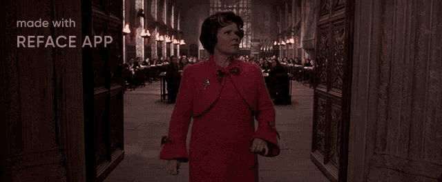 a woman in a red dress is walking down a hallway in front of a crowd .
