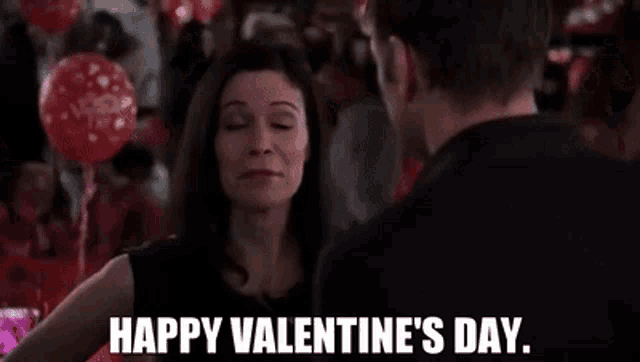 a woman is dancing with a man at a valentine 's day party and says `` happy valentine 's day . ''