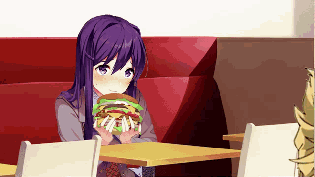 a girl with purple hair is sitting at a table holding a hamburger