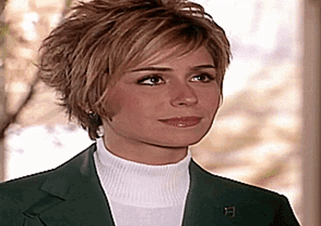 a woman wearing a green jacket and a white sweater