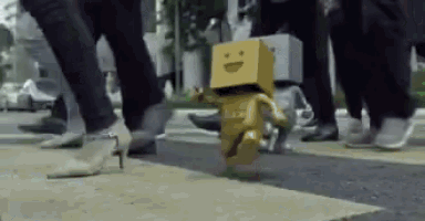 a cardboard box with a smiley face on it is running across a street