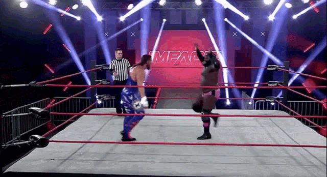 two wrestlers are in a ring with the word impact on the wall behind them