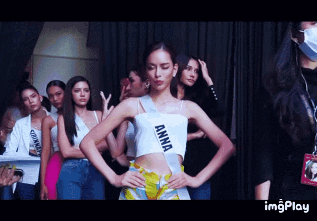 a woman wearing a white crop top with the word anna on it