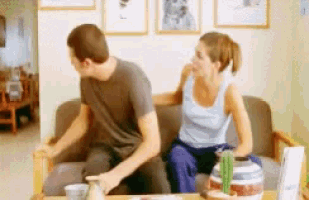 a man and a woman are sitting on a couch talking