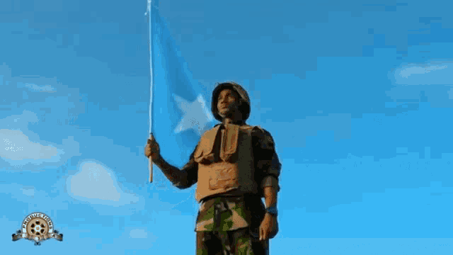 a man in a military uniform holds a flag with a star on it