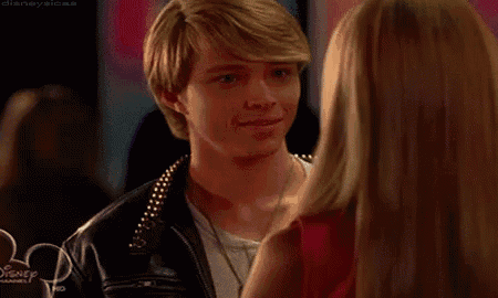 a man and a woman are looking at each other and smiling .