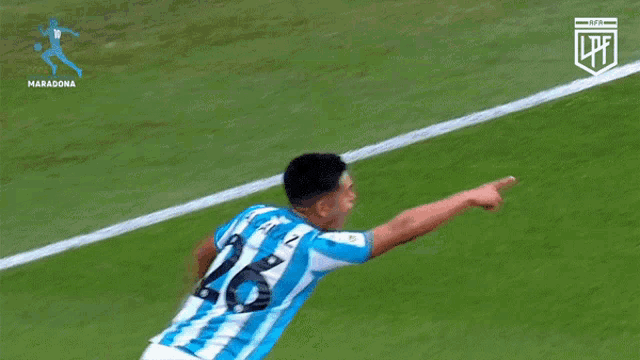 a soccer player with the number 26 on his shirt is pointing