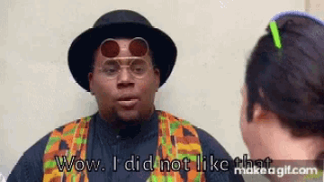 a man wearing a hat and sunglasses is talking to another man and says wow i did not like that