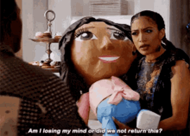 a woman is holding a stuffed doll while talking to another woman .