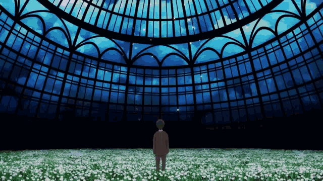 a man in a suit stands in a field of flowers in front of a large building