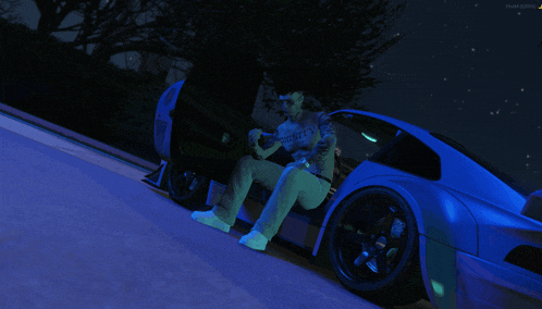 a man sits on the side of a car wearing a shirt that says twenty on it