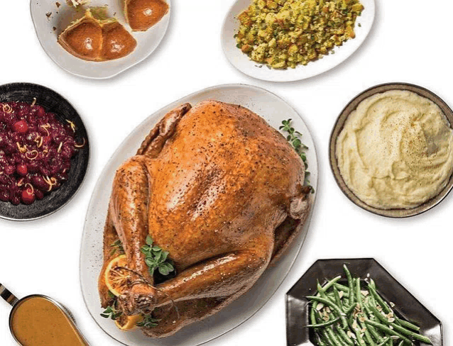 a turkey is surrounded by plates of food including green beans mashed potatoes and stuffing